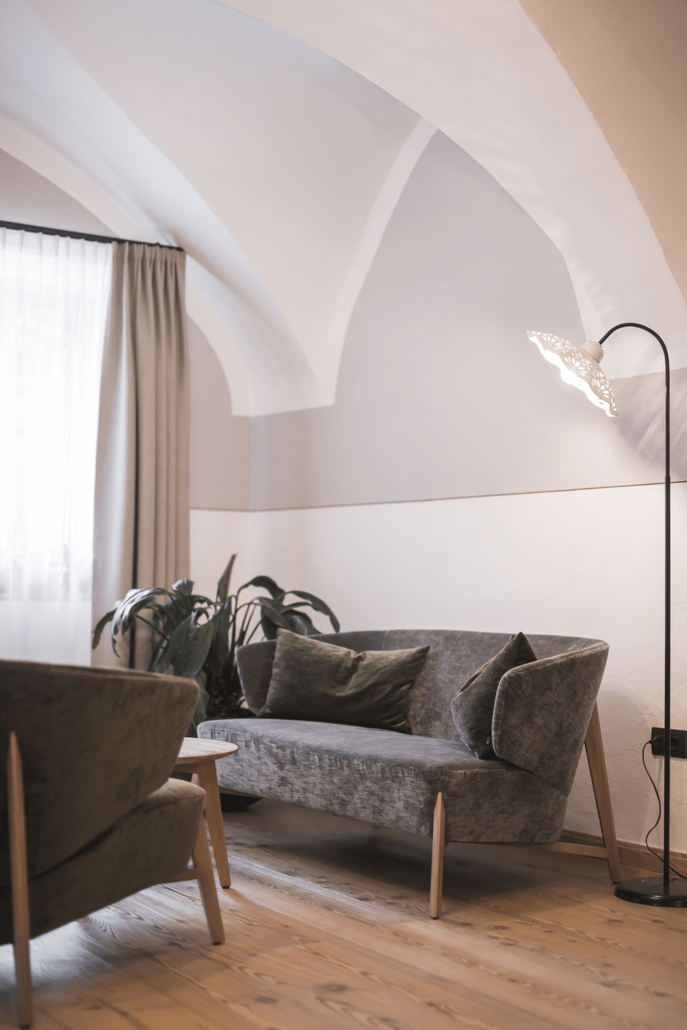 un divano grigio e una lampada a stelo